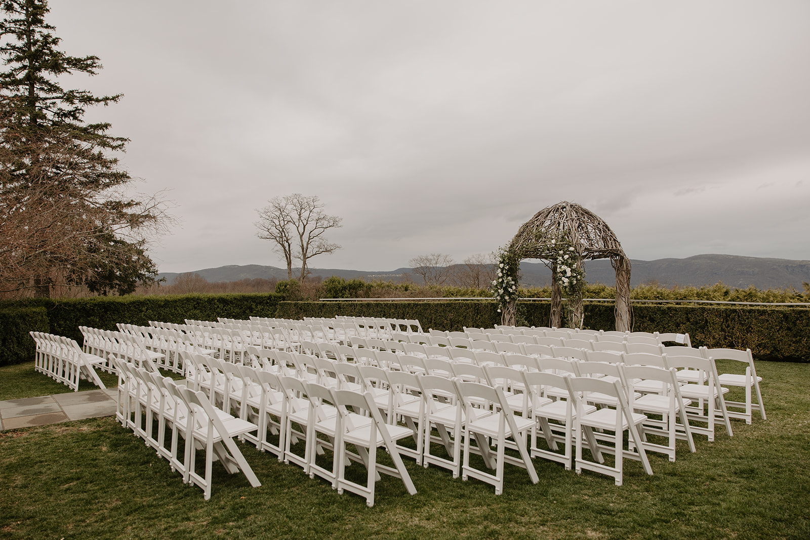 Empty outdoor ceremony chairs setup facing the arch at The Garrison in Garrison, NY with sweeping Hudson Valley views.