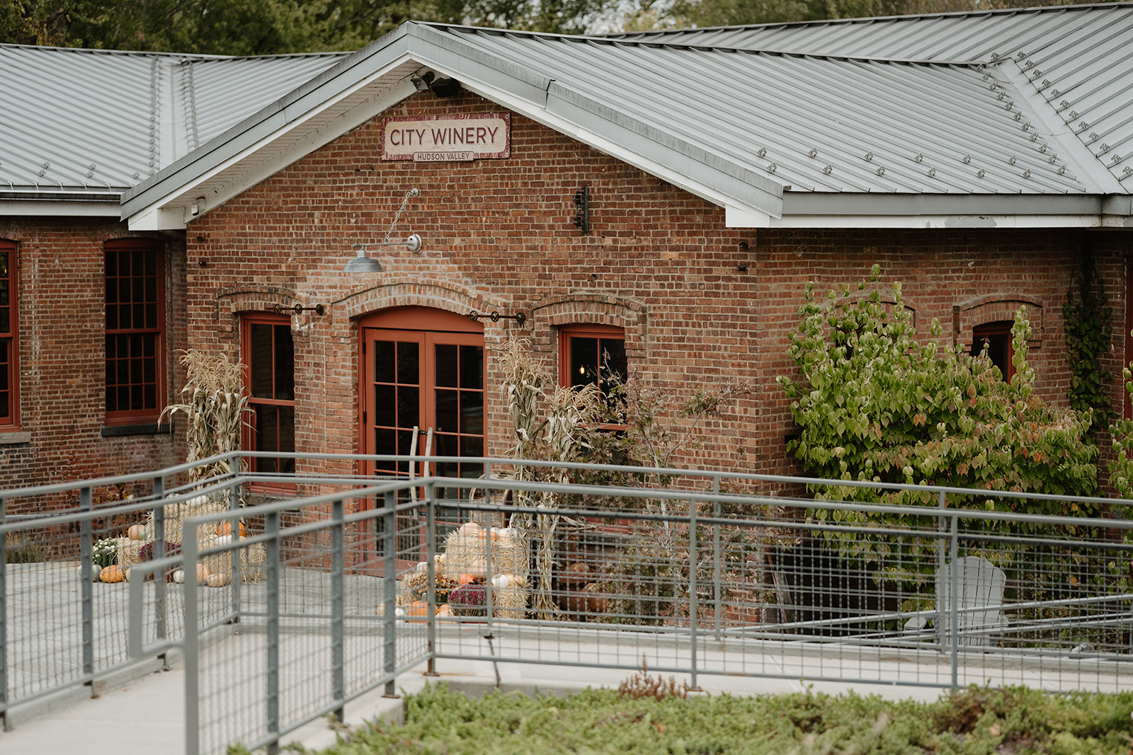 Brick exterior of City Winery in Hudson Valley decorated with festive autumn pumpkins and cornstalks.